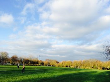 Scenic view of grassy field against cloudy sky