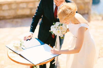 Cheerful bridegroom signing marriage registration