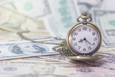 Close-up of clock on us paper currency