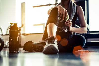 Low section of woman sitting in gym