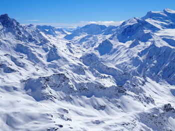 Scenic view of snowcapped mountain against blue sky