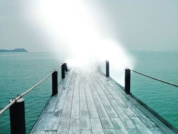 Jetty in sea against clear sky