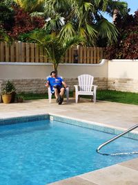 Man relaxing on chair at poolside