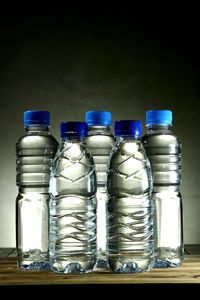 Close-up of water bottles against gray background