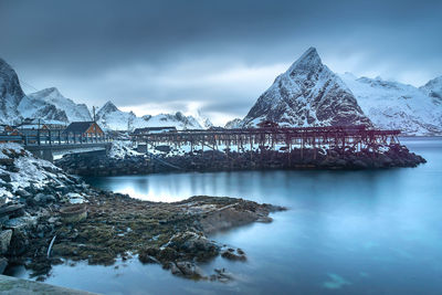 Scenic view of snowcapped mountains by sea against sky