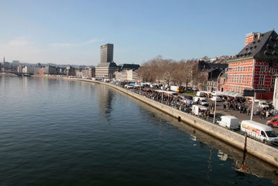 River amidst buildings in city against sky