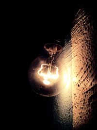 Close-up of illuminated lamp over black background