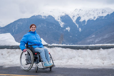 Rear view of man riding bicycle on snowcapped mountain