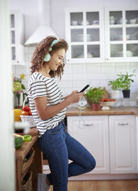 Young woman using mobile phone at home