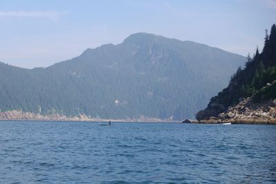 Scenic view of sea and mountains against sky