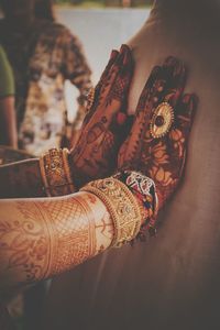 Close-up of bride with henna tattoo and bangles