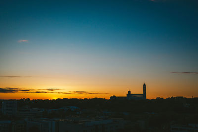 Silhouette buildings against sky during sunset