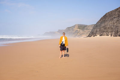 Rear view of man walking on beach