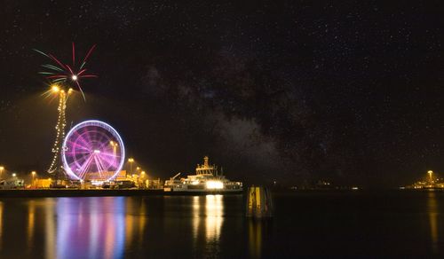 Illuminated ferris wheel at night