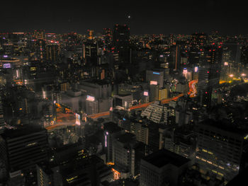 Illuminated cityscape against sky at night