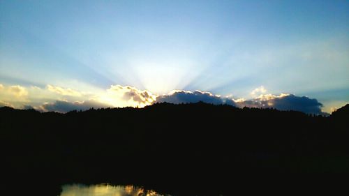 Silhouette of mountain against cloudy sky at sunset