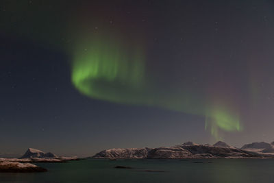 Scenic view of aurora borealis over sea at night