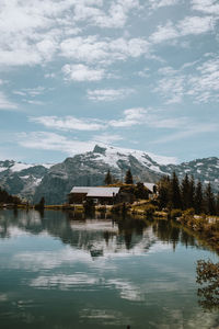 Houses by lake against sky during winter