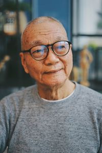 Close-up of thoughtful senior man looking away while sitting in cafe