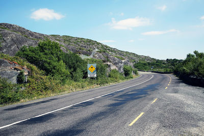 Road leading towards mountain against sky