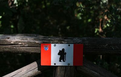 Close-up of sign on wooden post