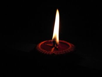 Close-up of illuminated candle in darkroom