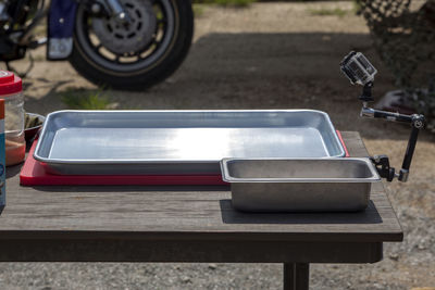 High angle view of empty metallic tray and container on table at field