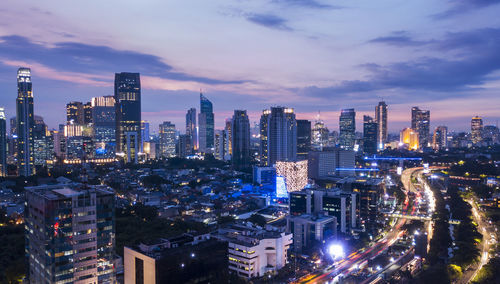 Illuminated cityscape against sky at night