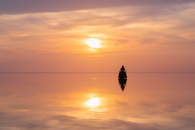 Silhouette woman standing at sunset