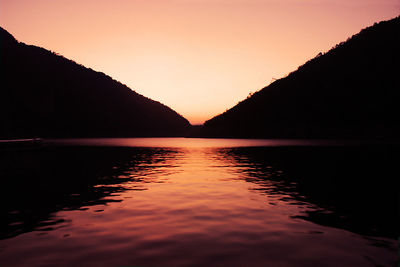 Scenic view of lake against romantic sky at sunset