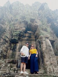 Full length portrait of couple standing at historical building