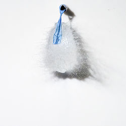 High angle view of snow covered over water against white background