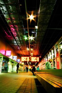People at illuminated railroad station at night