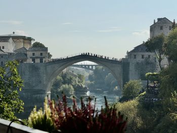 Arch bridge over river against sky