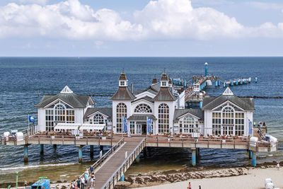 Buildings by sea against sky