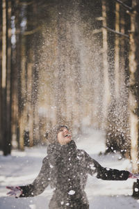 Woman throwing while playing with snow