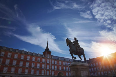 Low angle view of statue of building against cloudy sky