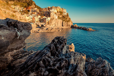 Rock formations by sea against sky