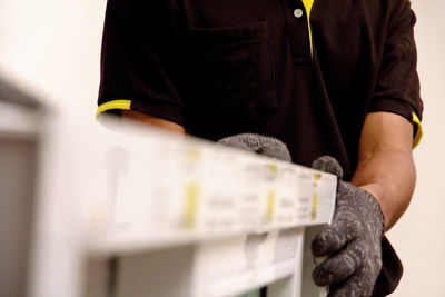 Midsection of worker holding window frame at home