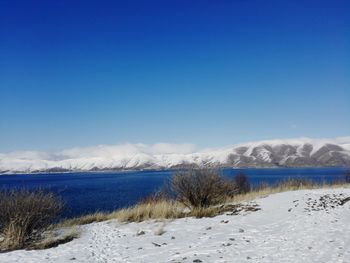 Scenic view of snowcapped mountains against blue sky