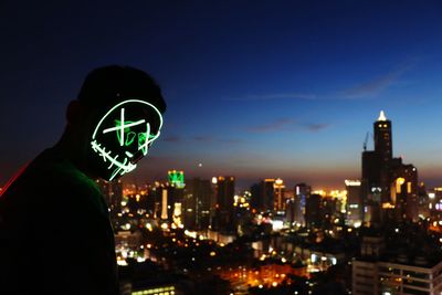 Illuminated cityscape against sky at night