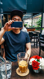 Portrait of man holding drink in restaurant