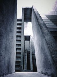 Low angle view of bridge amidst buildings against sky