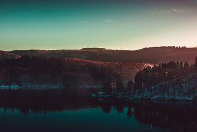 Scenic view of lake against sky at sunset