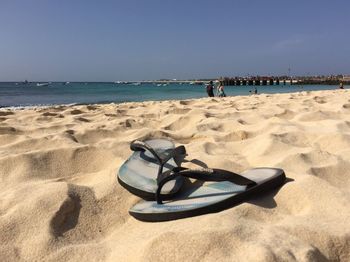 Deck chairs on beach against clear sky