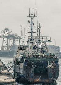 Ship moored in river against sky at harbor