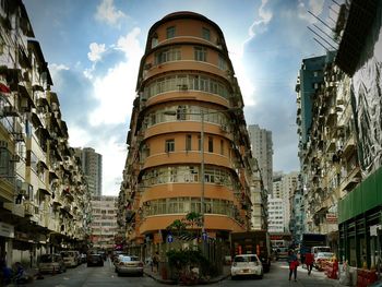 Buildings in city against cloudy sky