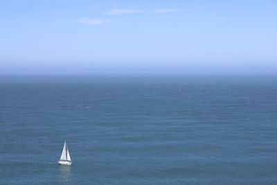 Sailboat sailing in sea against sky