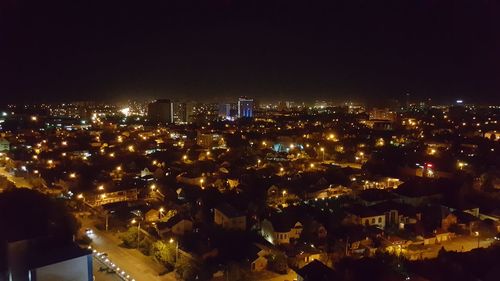 Illuminated cityscape against sky at night