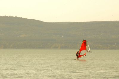 Man on boat in sea against sky